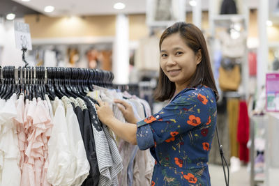 Portrait of a smiling young woman standing in store