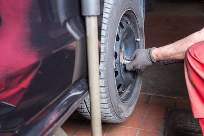 Man filling car tire with air at fuel station