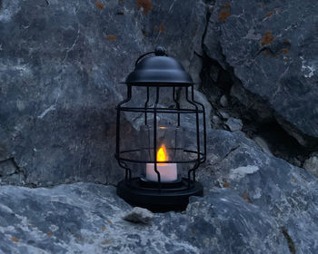 Close-up of illuminated lamp against wall