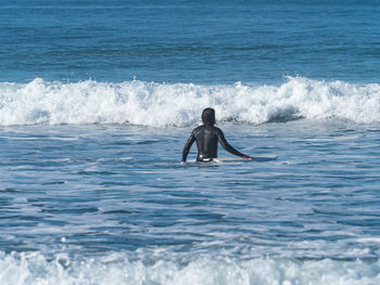 Rear view of man surfing in sea