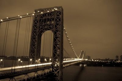 Suspension bridge over river at night