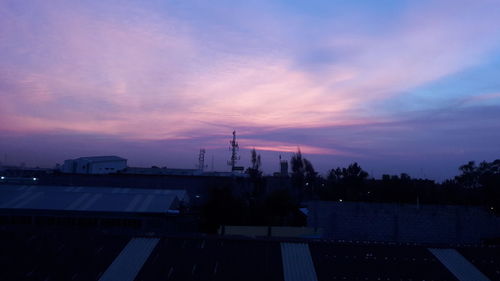 Factory against sky during sunset