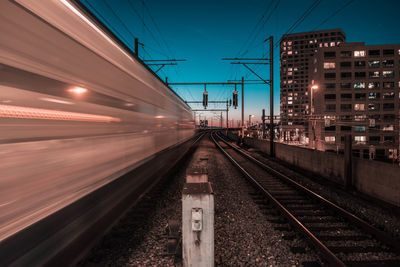 Railroad station platform against clear sky at night