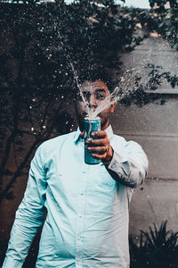 Man holding exploding drink can