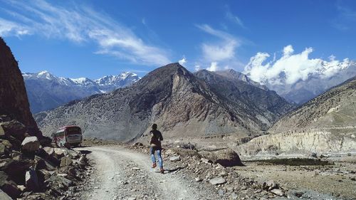 Rear view of person on snowcapped mountains against sky