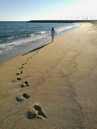 Man standing on beach against clear sky