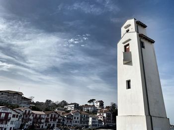 Low angle view of buildings against cloudy sky