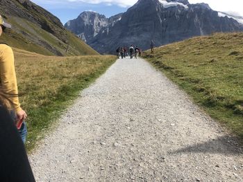 People walking on road amidst mountains