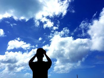 Low angle view of silhouette people standing against cloudy sky