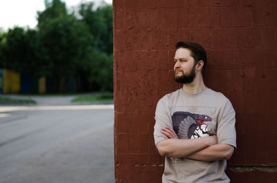 Young man standing against wall