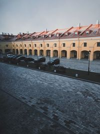 Road by buildings against sky in city