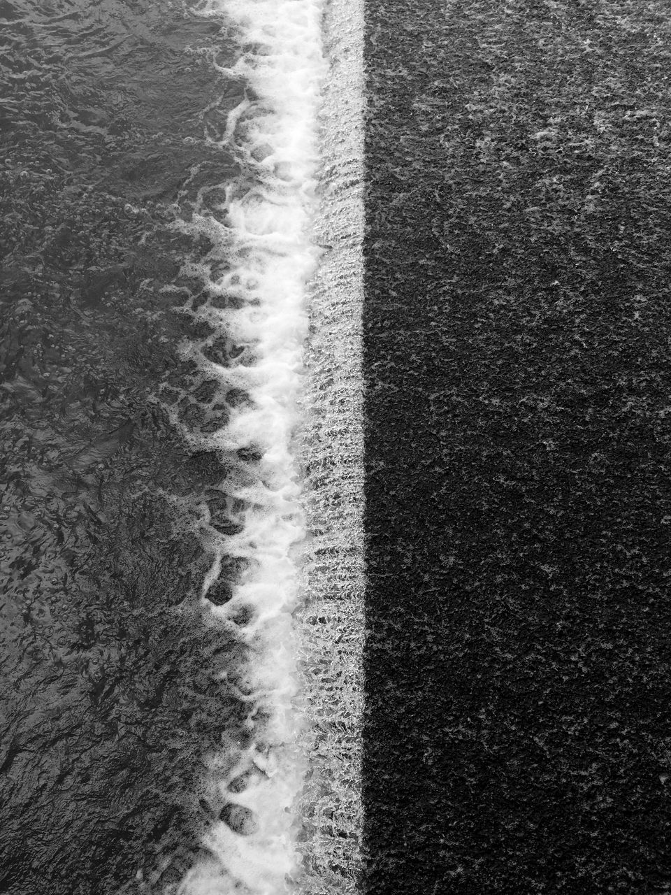 HIGH ANGLE VIEW OF WATER FLOWING THROUGH FROM LAND