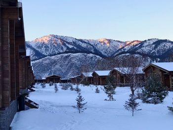 Snow covered houses and mountains against sky