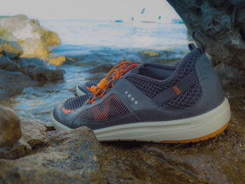 Close-up of shoes on beach