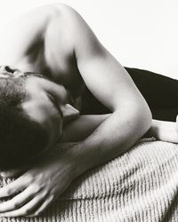 Close-up of shirtless man sleeping on bed at home