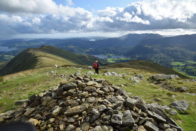 Rear view of woman standing on mountain against sky