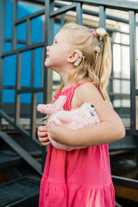 Side view of young woman standing in gym