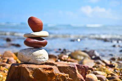 Close-up of pebbles on beach against sky