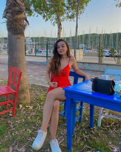 Portrait of smiling young woman sitting on bench 