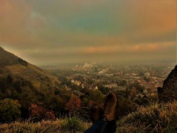 Low section of man on mountain against sky