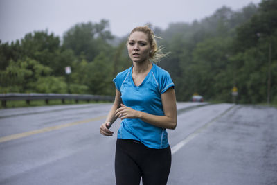 Full length of young woman standing on road