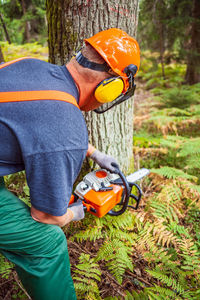 Midsection of man working in forest