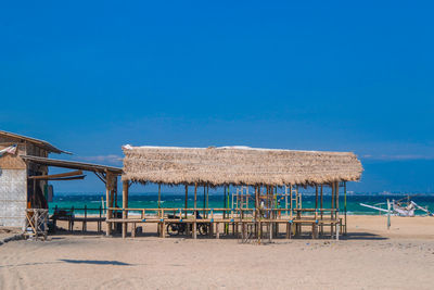 Built structure on beach against clear blue sky