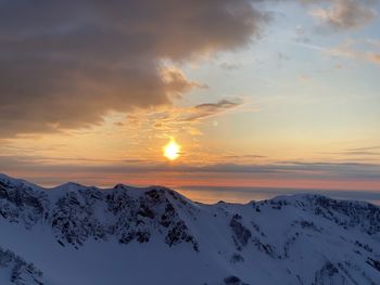 Scenic view of snowcapped mountains against sky during sunset