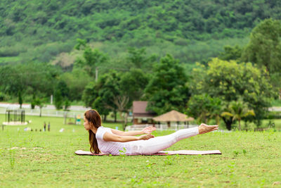 Full length of woman doing yoga on grass 