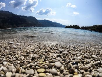 Surface level of stones on beach against sky