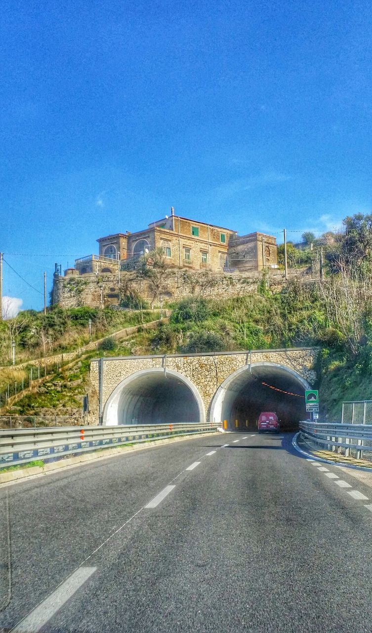 architecture, built structure, building exterior, road, transportation, blue, clear sky, street, car, city, road marking, the way forward, land vehicle, sky, arch, copy space, connection, outdoors, diminishing perspective, day