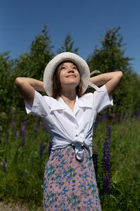 Young woman wearing hat standing on field