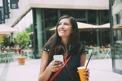 Portrait of a smiling young woman using smart phone