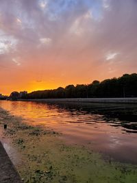 Scenic view of lake against orange sky