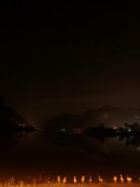 Scenic view of lake against sky at night