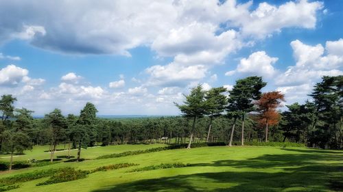 Scenic view of green landscape against cloudy sky