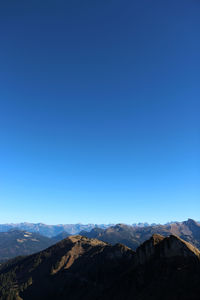 Scenic view of mountains against clear blue sky