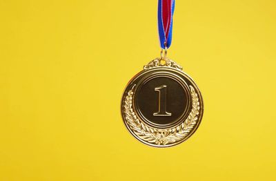 Close-up of clock against yellow wall