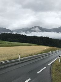 Road leading towards mountains against sky