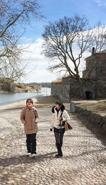 Men at beach against sky
