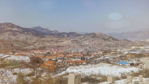 Aerial view of houses and mountains against sky