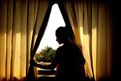 Close-up of woman looking through window