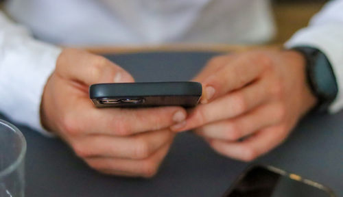 Midsection of man using mobile phone