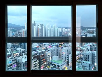 Cityscape against sky seen through glass window