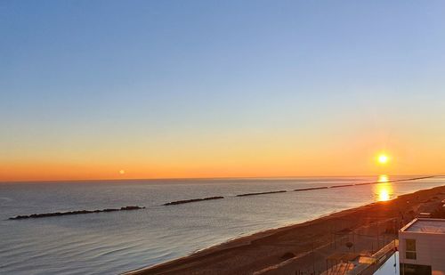 Scenic view of sea against clear sky during sunset