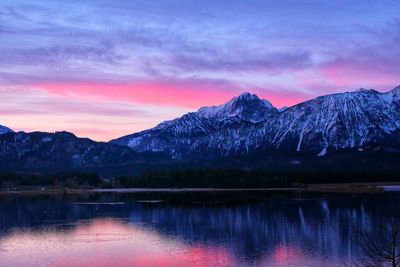 Scenic view of lake and mountains against sky during sunset