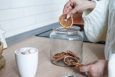 Midsection of woman holding coffee on table