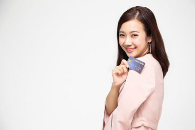 Portrait of a smiling young woman against white background