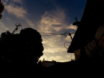 Low angle view of silhouette building against cloudy sky