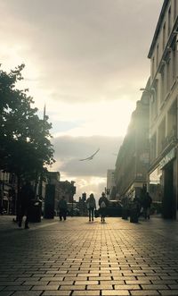 People on street in city against sky